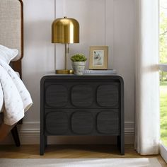 a bed room with a neatly made bed and a night stand next to a window