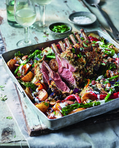 a roasting pan filled with meat and veggies on top of a table