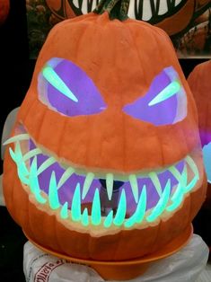 a pumpkin with glowing eyes and teeth on it