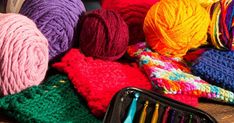 several balls of yarn and crochet hooks sitting on a table next to each other