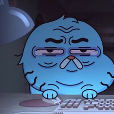 a blue cartoon character sitting in front of a computer keyboard with eyes drawn on it