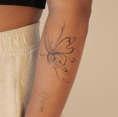 a woman's arm with a butterfly tattoo on the left side of her arm