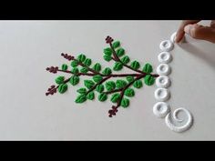 someone is working on an art project with green leaves