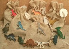 small bags filled with dinosaur toys sitting on top of a floor next to a wall