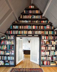 a room filled with lots of books on top of a book shelf next to a doorway