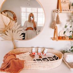 a woman taking a selfie in front of a mirror with her cell phone and other items