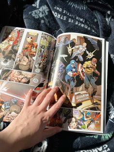 a person is holding an open comic book