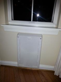 a white radiator sitting in front of a window next to a wooden floor