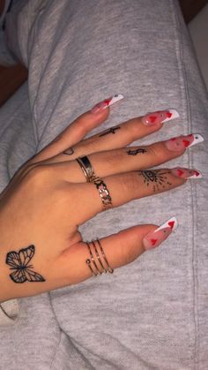 two women's hands with tattoos on their fingers