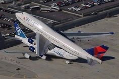 an airplane is parked on the tarmac in front of many other planes and cars