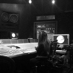 a woman sitting in front of a mixing desk