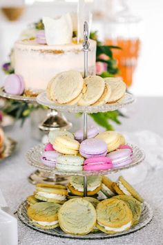 three tiered trays with cookies and pastries on top of each other, next to a cake