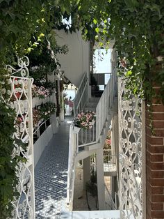 the stairs lead up to an apartment building with flowers growing on it's balconies