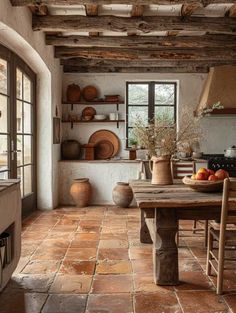 a rustic kitchen with stone flooring and exposed beams