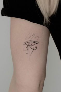 a woman's lower thigh with an eye tattoo on it