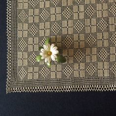 a white flower sitting on top of a piece of cloth