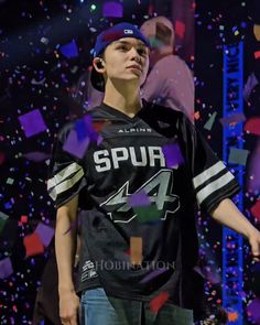 a young man standing in front of confetti