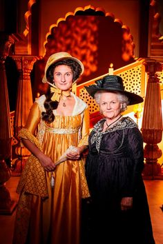 two women dressed in period costumes standing next to each other