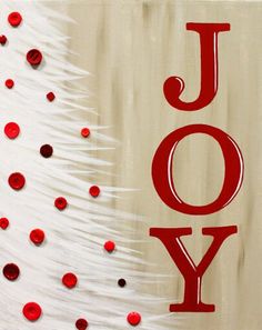 a white christmas tree with red confetti on it and the word joy spelled out