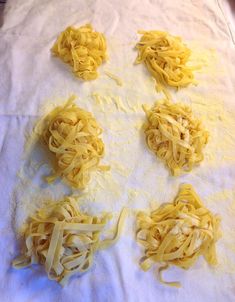 several pieces of pasta are being made on a sheet of white paper with holes in the middle