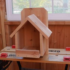 a wooden bird house sitting on top of a table