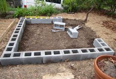 a garden area with concrete blocks and tools