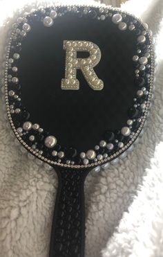 This listing is for a hand mirror customized  with pearls, rhinestones, and one white pearl letter.  The base color of the mirror is black and automatically comes with black and white pearls. You may choose a third accent color and one letter of your choice.  Your finished product may not look exactly like the mirror shown because it is a custom item.  We DO NOT offer refunds. If you are unhappy with your item please message us so that we may discuss a possible resolution. Your happiness is important to us!  We are NOT responsible for any lost or damaged items.  Please message us if you have any questions or concerns prior to ordering.  Thank you for visiting Kingdom Bling Co! Bedazzled Mirror, Bedazzling Ideas, Rhinestone Mirror, Bling Things, Bath Stuff, Diamond Dots, Pearl Letters, Pink Lifestyle, Glam Decor