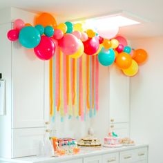 balloons and streamers are hanging from the ceiling in this party - ready kitchen area