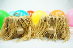 two scarecrow heads made out of straw with balloons in the background