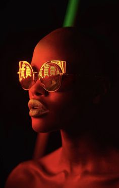 a woman wearing sunglasses with houses reflected in it's lenses, while the image is red