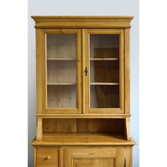 a wooden hutch with glass doors and drawers on the front, sitting against a white wall