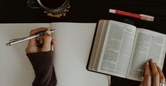 two people are writing on an open book