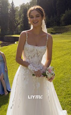 a woman in a wedding dress standing on the grass