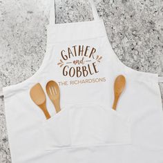 a white apron with wooden spoons on it that says gather and gobble the richardsons