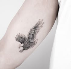 an eagle tattoo on the left arm