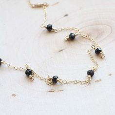 "Scattered Spinel Gemstone Necklace The most tiny & dainty everyday necklace. Featuring seven tiny black spinel rondelles (~4mm each) that are hand wrapped to the most delicate & shimmering 14k gold fill chain. A gorgeous necklace that you will reach for everyday.. Necklace measure 17 inches as pictured. Completed with a round spring clasp. ♥Your purchase will come thoughtfully packaged and ready for gift giving. If this purchase is a gift that we are shipping directly to the recipient, Gift Black Spinel Round Bead Jewelry, Black Spinel Round Beads Jewelry For Gifts, Minimalist Black Spinel Necklace As Gift, Black Spinel Gemstone Necklace For Gift, Gift Necklace With Black Spinel And Beads, Gift Black Spinel Necklace With Black Beads, Black Spinel Necklace With Black Beads For Gift, Black Spinel Beaded Necklace For Gifts, Dainty Jewelry With Black Beads For Gifts