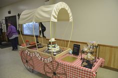 a table that has some food on it and people standing in the background behind it