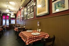 an empty restaurant with red and white checkered tablecloths on the dining room