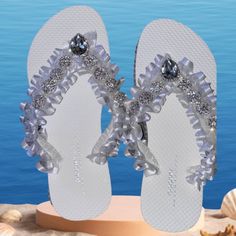 Experience The Artistry And Beauty Of Handcrafted Footwear. Order Your Pair Of These Exquisite Flip Flops Today And Let Your Wedding Day Be A Fairytale Filled With Love, Laughter, And Unforgettable Moments. Pretty Wedding Sandals, Sand Shoes Size 6 There Are Many Occasions Where You Can Use Luxury Gorgeous Flip Flops, Including: Beach Weddings: These Luxurious Flip Flops Are Perfect For A Beach Wedding, Providing A Comfortable And Stylish Option For The Bride Or Bridesmaids. Bridal Showers: A Gr Bedazzled White Wedding Shoes For Party, White Bedazzled Wedding Shoes For Party, Silver Rhinestone Wedding Shoes For Bridal Shower, White Open Toe Wedding Shoes With Rhinestones, Shoes Beach Wedding, Beach Bridesmaids, Old Navy Flip Flops, Sand Shoes, Glitter Flip Flops