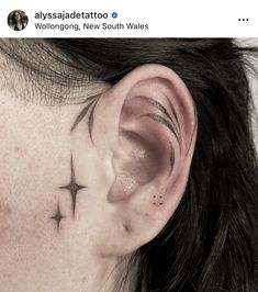 a woman's ear has a star tattoo on it