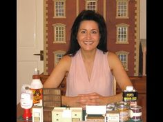 a woman sitting at a table in front of a doll house with lots of items on it