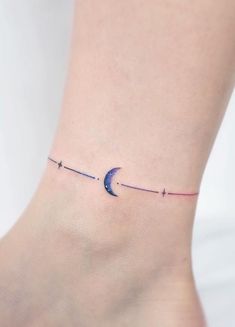 a small tattoo on the ankle of a woman's foot with a crescent moon and stars