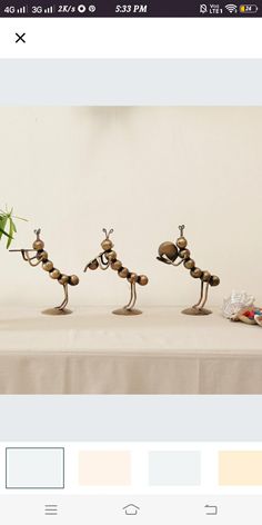 three small figurines sitting on top of a table next to each other and one is holding a bamboo plant