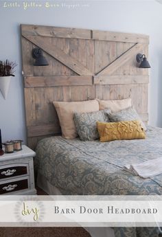 a bed with a wooden headboard made out of barn door doors and pillows on it