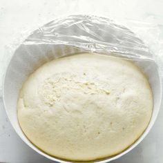 an uncooked pizza dough in a white bowl