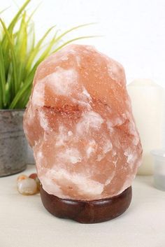 a large pink rock sitting on top of a table next to a potted plant