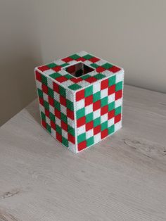 a red and green box sitting on top of a wooden table