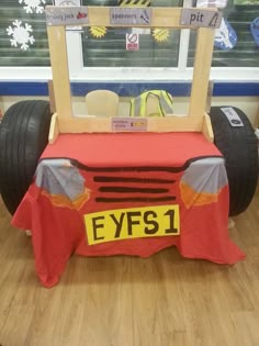 an eye car made out of construction equipment on display in a room with wooden floors