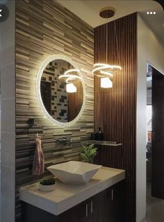 a bathroom with a sink, mirror and lights on the wall in it's corner