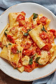 a white plate topped with ravioli and tomatoes